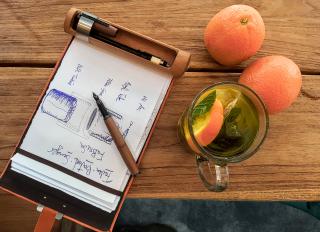 A Rollgut Pear-Orange in action, lying on the table along a tea and oranges